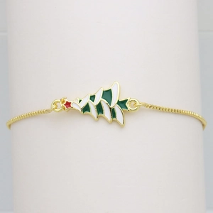 Detail of a gold-plated box chain bracelet featuring a green enamel Christmas tree charm