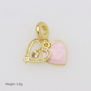 Close-up of heart-shaped gold charm with pink enamel and sparkling zircon stones