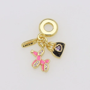 Detailed shot of gold lucky tag, pink enamel balloon dog, and purple heart charms