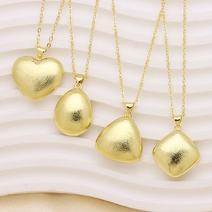 Collares minimalistas de oro mate con colgantes de corazón y geométricos sobre fondo ondulado