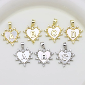 Detail of heart shell alphabet pendants with micro-pave zirconia in gold and silver