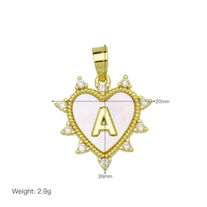 Macro detail of heart-shaped letter A pendant with shell inlay and cubic zirconia