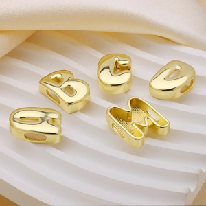 Detailed view of gold-plated metal alphabet beads A B C D M for DIY jewelry making