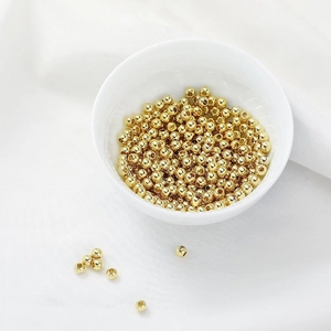 Polished 14K gold filled round beads for DIY jewelry making displayed in a white bowl
