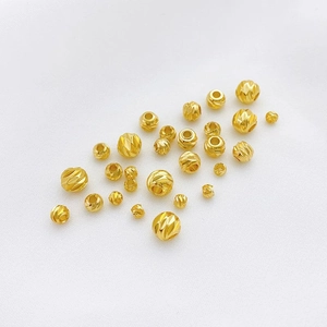 Vista macro detallada de cuentas espaciadoras facetadas de oro de 14K en varios tamaños