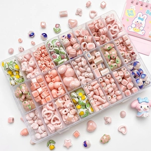 Macro view of cherry blossom ceramic beads in a 24-grid organizer for DIY jewelry making