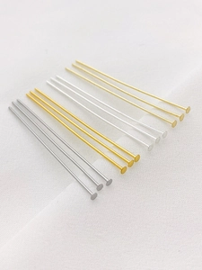 Macro detail of 14K gold-plated and silver flat head pins for handmade jewelry DIY
