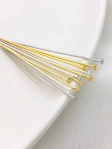 Macro detail of 14K gold and silver plated flat head pins for DIY jewelry making