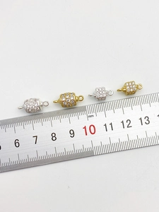 Macro view of 14K gold plated CZ hollow double ball connectors with a measuring ruler