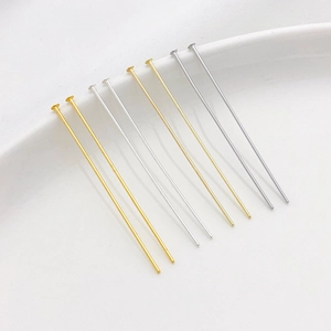 Close-up of gold and silver plated headpins for DIY jewelry making on white background