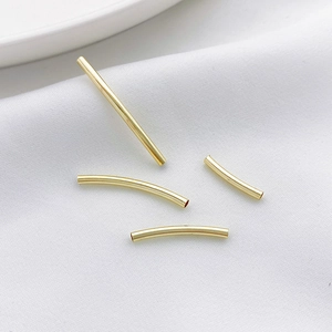 Nahaufnahme von 14K Gold gefüllten gebogenen und geraden Hohlperlen für DIY-Schmuckbau