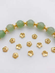 Macro view of 14K gold plated flower bead caps on a green jade bead bracelet