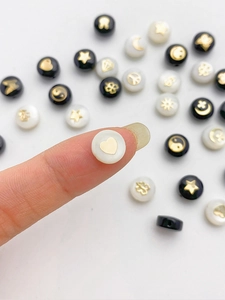 Vista macro de una cuenta de concha bañada en oro de 14K con motivo de corazón para DIY