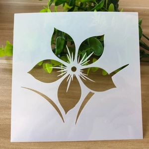 Macro detail of a white floral painting stencil with leaves on a natural wooden background