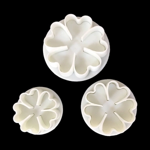 Set of 3 white floral heart fondant plungers for cake decorating on black background