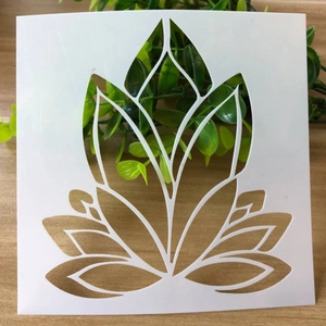 Detail of a white PET lotus stencil for DIY drawing on a rustic wooden background