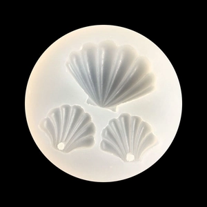 Translucent silicone shell mold with three shell cavities on a black background