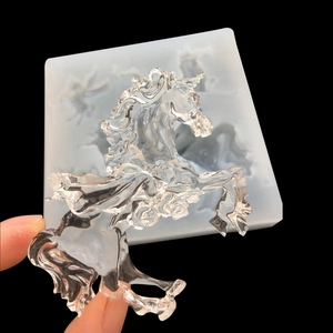 Translucent silicone mold with clear resin unicorn figurine on a black background