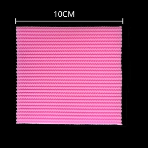 Macro detail of a 10cm pink silicone fondant mat with woven embossed texture for baking