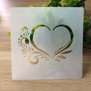 Macro shot of white translucent heart stencil with leaf patterns on wood surface