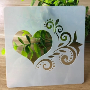 Detail of DIY heart and floral scroll hollow template on natural wooden background