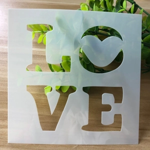 Macro detail of a square white PET stencil featuring a bold LOVE cutout for DIY crafts