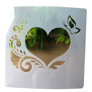 DIY cake stencil with heart, butterfly and vine pattern on light wood background