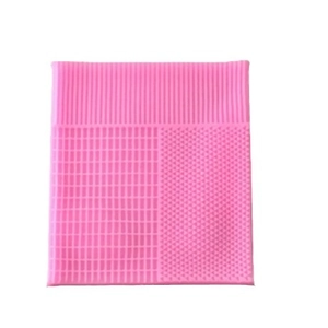 Pink silicone texture mat with three cleaning patterns for makeup brushes on white background