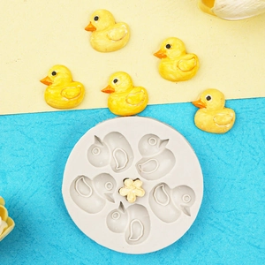 Detail of round silicone mold with mini ducks and flower cavities for clay or baking
