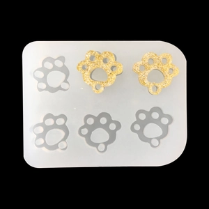DIY silicone mold for resin craft featuring six cat paw shape slots with gold glitter finish