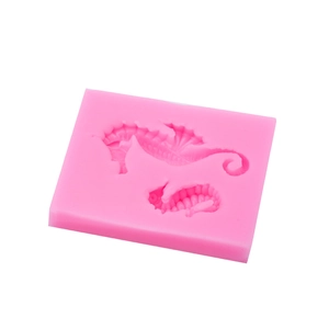 Pink silicone seahorse mold for fondant and chocolate cake decorating on white background