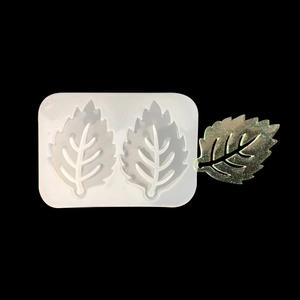 Dual-cavity leaf silicone mold with green resin casting on black background
