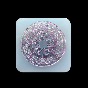 Macro detail of round resin mold featuring purple glitter star and geometric patterns