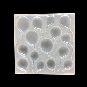 Macro shot of 14 balloon shapes in a square translucent silicone mold with dark background