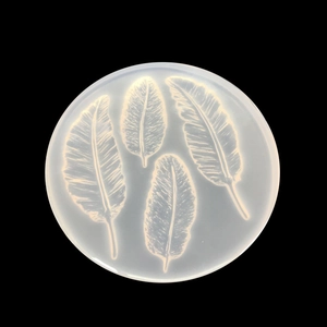 Translucent round silicone mold featuring four detailed feather patterns for DIY crafts