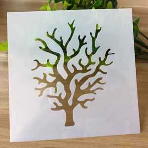 Detailed view of a white plastic square stencil with coral branch patterns for DIY crafts