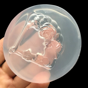 Hand holding a translucent silicone mold with a detailed rose flower relief design