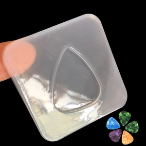 Macro view of transparent silicone guitar pick mold with colorful resin samples
