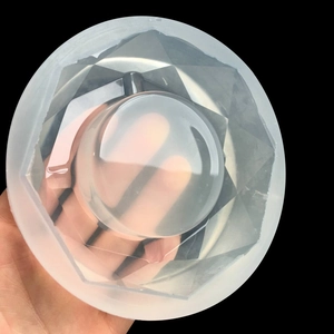 Close-up of a 10cm round silicone ashtray mold with geometric facets and smooth finish