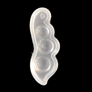 Pea pod shape silicone mold for DIY jewelry with three spheres on black background