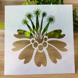 Detail view of white square hollow stencil with radial floral patterns on a wooden desk