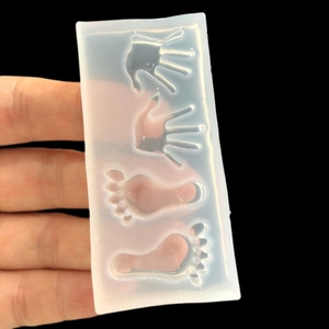 Translucent silicone mold featuring small hand and footprint shapes for DIY resin crafts