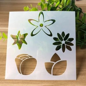 Close-up of white PET plastic floral stencils for DIY painting on a wooden surface