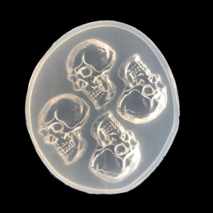 Macro detail of a round silicone mold with four skull designs for DIY resin crafts