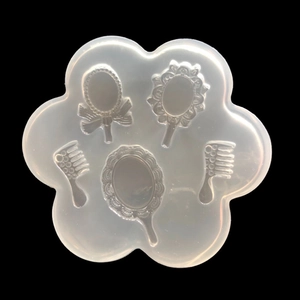 Macro detail of silicone mold featuring vintage mirror and comb shapes for resin crafts