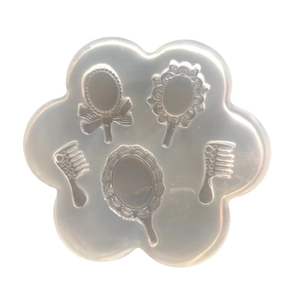 Translucent silicone mold featuring vintage handheld mirror and comb shapes for DIY resin crafts