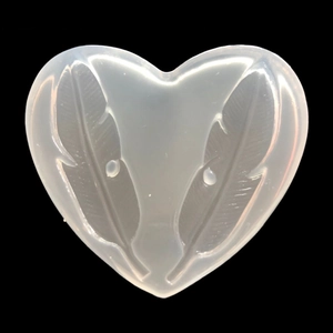 Detail view of a heart-shaped silicone mold with feather pattern for resin and clay crafts