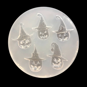 Detailed macro view of white silicone mold with five Halloween pumpkin and wizard hat shapes