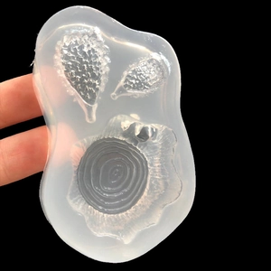 Translucent silicone mold featuring 3D cartoon hedgehog and tree stump designs for DIY resin crafts