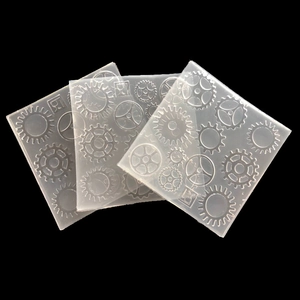 Detailed view of three square silicone molds with intricate gear patterns for DIY crafts